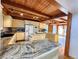 Bright, open-concept kitchen, boasting an island cooktop, granite counters and stainless appliances with exposed beams above at 2418 W Euclid Ave, Littleton, CO 80120