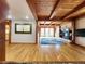 Open living room with hardwood floors, wooden beam ceiling, and modern fireplace at 2418 W Euclid Ave, Littleton, CO 80120