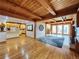 Spacious living room featuring hardwood floors, wooden beam ceiling, and adjacent kitchen view at 2418 W Euclid Ave, Littleton, CO 80120