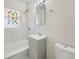 Bright bathroom featuring a tub with tile surround, decorative window and updated vanity at 2865 S Fairfax St, Denver, CO 80222