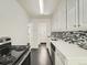 Modern kitchen featuring white cabinets, stainless steel appliances, mosaic backsplash and hardwood floors at 2865 S Fairfax St, Denver, CO 80222