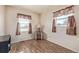 Bright bedroom featuring wood-look flooring and two windows with patterned curtains at 381 El Paso Ct, Denver, CO 80221