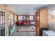 View of the enclosed patio featuring red and yellow walls, concrete floors, an antique stove and a vintage bench at 381 El Paso Ct, Denver, CO 80221