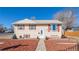 Charming two-story home featuring light-colored siding, red shutters, and a well-maintained front yard with mulch at 381 El Paso Ct, Denver, CO 80221