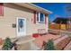 Inviting front porch with red metal chairs and landscaping at 381 El Paso Ct, Denver, CO 80221