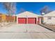 Two-car garage with red doors and a large driveway at 381 El Paso Ct, Denver, CO 80221