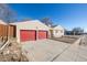 Detached two-car garage featuring red doors and ample parking space, enhancing the property's functionality at 381 El Paso Ct, Denver, CO 80221