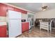 Kitchen features red cabinets, white appliances and wood flooring at 381 El Paso Ct, Denver, CO 80221