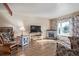 Cozy living room with hardwood floors, a stone fireplace, and a large window that brings in plenty of natural light at 381 El Paso Ct, Denver, CO 80221