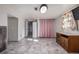 Well lit living room with grey vinyl flooring, light grey walls, and a vintage entertainment stand at 381 El Paso Ct, Denver, CO 80221