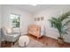 Light-filled Bedroom features wood floors, a crib, a comfortable chair, and natural light at 3047 N Milwaukee St, Denver, CO 80205
