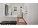 Bright kitchen boasts white cabinets, stainless steel appliances, a breakfast bar, and hardwood floors at 3047 N Milwaukee St, Denver, CO 80205