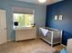 Bedroom with ample natural light, comfortable crib and a dresser with changing table at 9557 W San Juan Cir # 207, Littleton, CO 80128