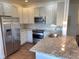 Modern kitchen featuring stainless steel appliances, stone countertops, and a tile backsplash at 9557 W San Juan Cir # 207, Littleton, CO 80128