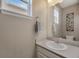 Powder room with white vanity, chrome fixtures, framed mirror, and decorative artwork at 17124 Mariposa St, Broomfield, CO 80023