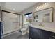 Sleek bathroom with glass enclosed shower, blue vanity with marble top, gold fixtures, and modern lighting at 17124 Mariposa St, Broomfield, CO 80023
