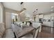 Open-concept dining area featuring a rustic wood table, bench seating, and modern pendant lighting at 17124 Mariposa St, Broomfield, CO 80023