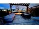 Backyard fire pit with dining and lounge area under wooden pergola at 17124 Mariposa St, Broomfield, CO 80023