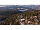 Aerial view of a home nestled in a snowy mountain forest at 22598 Westview Ave, Golden, CO 80401