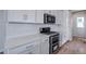 Close up of modern kitchen featuring stainless steel oven, white cabinets, and subway tile at 24801 E 33Rd Dr, Aurora, CO 80019