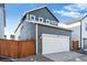 Rear exterior view of the house showing the garage and wooden fence at 2031 Generations Aly, Brighton, CO 80601