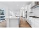 Bright kitchen features white cabinets, stainless appliances, and large island with sink at 2031 Generations Aly, Brighton, CO 80601