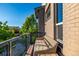 Exterior view of the wood balcony featuring black iron railings, outdoor seating, and a brick facade at 10305 Martin Luther King Blvd, Denver, CO 80238