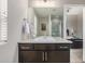This bathroom shows off a vanity with a white countertop, dark wood cabinets, and a large mirror at 10305 Martin Luther King Blvd, Denver, CO 80238