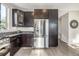 A stainless steel refrigerator and dark wood cabinets offer ample kitchen storage at 10305 Martin Luther King Blvd, Denver, CO 80238
