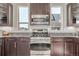 The kitchen's stainless steel stove and microwave sit between granite countertops and windows at 10305 Martin Luther King Blvd, Denver, CO 80238
