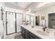 Elegant bathroom featuring double sinks, stylish fixtures, and a walk-in shower at 162 Starlight Cir, Erie, CO 80516