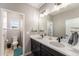 Beautifully designed bathroom with double sinks, quartz countertops, and modern lighting fixtures at 162 Starlight Cir, Erie, CO 80516