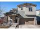 Inviting two-story home featuring a covered porch with stone accents and a two car garage at 162 Starlight Cir, Erie, CO 80516