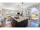 Open-concept kitchen island with granite countertops connecting the dining and living areas at 162 Starlight Cir, Erie, CO 80516
