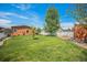 Spacious backyard with a well-maintained lawn, mature trees, and a charming white picket fence at 7930 Larkspur Cir, Frederick, CO 80530