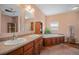Bathroom featuring double sinks, a soaking tub, and wood floors creating a luxurious and comfortable space at 7930 Larkspur Cir, Frederick, CO 80530