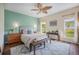 Charming bedroom features a leaf ceiling fan, and natural light from large windows overlooking the yard at 7930 Larkspur Cir, Frederick, CO 80530