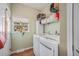 Efficient laundry room with a modern washer and dryer, overhead shelving, and natural light from a window at 7930 Larkspur Cir, Frederick, CO 80530