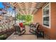 Inviting outdoor patio under a striped awning, featuring rocking chairs and views of the landscaped yard at 7930 Larkspur Cir, Frederick, CO 80530
