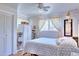 Bright bedroom with white trim, ceiling fan, large windows, and modern bedding at 8561 E Grand Ave, Denver, CO 80237