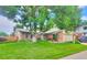 Charming brick home featuring a lush lawn, mature tree, and inviting curb appeal at 8561 E Grand Ave, Denver, CO 80237