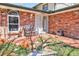 Inviting front porch with brick facade, seating and a beautiful garden at 8561 E Grand Ave, Denver, CO 80237