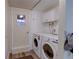 Clean laundry room with white washer and dryer, cabinets, and a door with a window at 8561 E Grand Ave, Denver, CO 80237