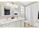 Well-lit bathroom featuring double sinks, white cabinetry, and shower-tub combo for added convenience and style at 1449 Braewood Ave, Highlands Ranch, CO 80129