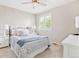 Cozy bedroom with ample natural light, carpet floors, stylish lamps, and bed with patterned quilts and pillows at 1449 Braewood Ave, Highlands Ranch, CO 80129