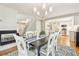Open dining space featuring hardwood floors, decorative lighting, and fireplace adjacent to the kitchen at 1449 Braewood Ave, Highlands Ranch, CO 80129
