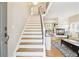 Bright entryway showcases a staircase, hardwood floors, and a view into the living room at 1449 Braewood Ave, Highlands Ranch, CO 80129