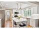 Modern white kitchen with island seating, stainless appliances, and ample storage with natural light at 1449 Braewood Ave, Highlands Ranch, CO 80129
