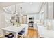 Bright white kitchen featuring an island with seating, stainless steel appliances and hardwood floors at 1449 Braewood Ave, Highlands Ranch, CO 80129