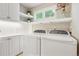 Bright laundry room with white cabinetry, shelving, and modern washer and dryer at 1449 Braewood Ave, Highlands Ranch, CO 80129